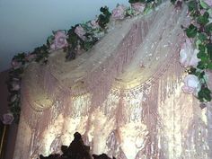 the curtain is covered with pink flowers and greenery on it's side wall