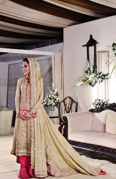 a woman in a bridal gown standing next to a couch