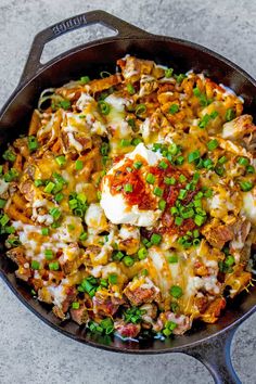 a skillet filled with eggs, meat and vegetables on top of a countertop