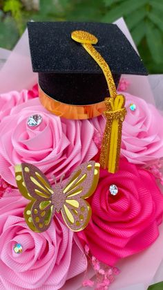 a graduation cap on top of pink flowers