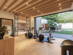 an indoor gym area with exercise equipment and large sliding glass doors leading to the back yard