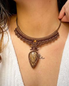 a close up of a woman wearing a necklace with a heart shaped pendant on it