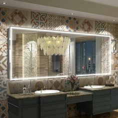 a bathroom with two sinks and a large mirror in it's center, surrounded by wallpaper