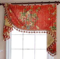 the window is decorated with red flowers and tassels on it's valance