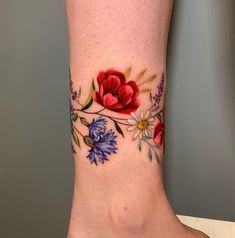 a close up of a person's foot with flowers painted on the bottom part of it