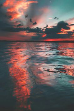 the sky is reflected in the water at sunset