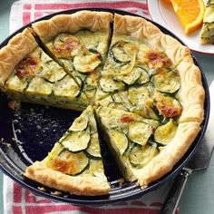 there is a pie with zucchini and oranges on the table