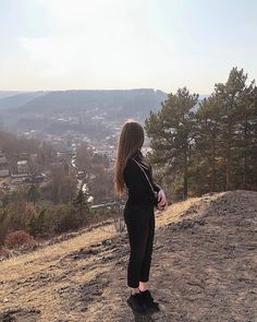 a woman standing on top of a hill