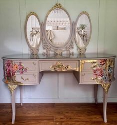 an antique vanity with three mirrors and flowers on it