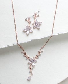 Dainty and elegant Rose gold Bridal jewelry set. Created in a lovely vine floral design that sparkles with Cubic zirconia stones - Necklace measures 16 inches and extends to 18 inches- Earrings dangle 1-3/8"- Rose gold finish- Premium cubic zirconia stones - Nickel free- Available in rose gold, yellow gold and rhodium finish. PLEASE ALLOW APPROX 10 BUSINESS DAYS FOR COMPLETION BEFORE SHIPPING. FOR MATCHING PIECES SIMPLY TYPE "LILY" IN THE SEARCH BAR Delicate Rose Gold Cubic Zirconia Bridal Necklace, Elegant Rose Gold Necklace With Matching Earrings, Dazzling Rose Gold Bridal Necklace Gift, Dazzling Rose Gold Bridal Necklace, Rose Gold Bridal Jewelry, Rose Gold Flower, Stones Necklace