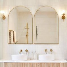 two white sinks sitting under mirrors in a bathroom