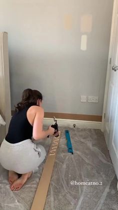 a woman kneeling on the floor with a tape measure