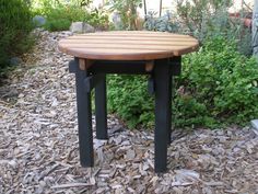 a wooden table sitting on top of a pile of wood chips