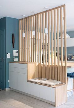 a kitchen with blue walls and wooden slats on the wall, along with white cabinets