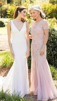 two women standing next to each other in dresses