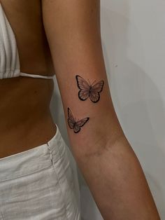 two butterflies tattoo on the right arm and left arm, both with one butterfly in it's center