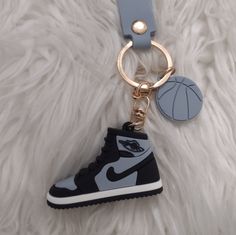 a keychain with a shoe and basketball ball on it sitting on a furry surface