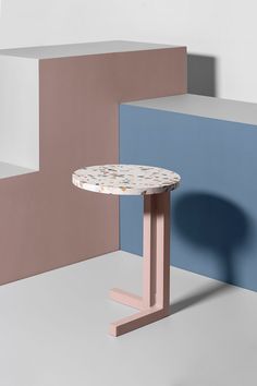 a small table sitting on top of a white floor next to colorful blocks in the background