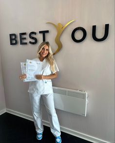 a woman in white scrubs holding up a piece of paper with the words best you on it