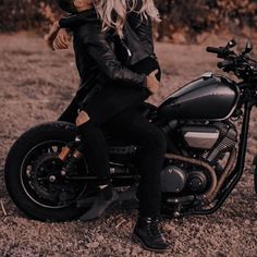 a woman sitting on top of a motorcycle