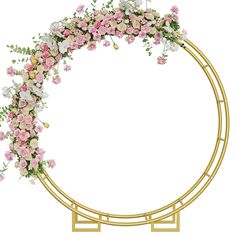 a circular gold frame with pink and white flowers on the top, surrounded by greenery