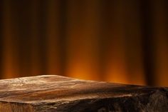 a piece of wood sitting on top of a wooden table next to a curtained wall