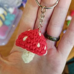 a hand holding a tiny crocheted mushroom keychain