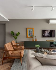 a living room filled with furniture and a flat screen tv mounted to the side of a wall