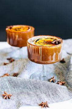 two desserts sitting on top of a table covered in chocolate and star anise