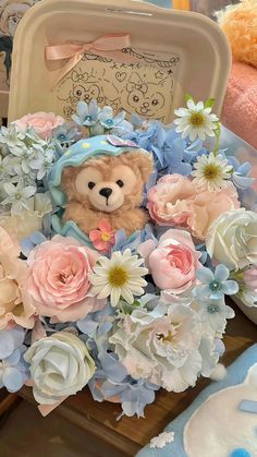 a teddy bear sitting in a bouquet of flowers