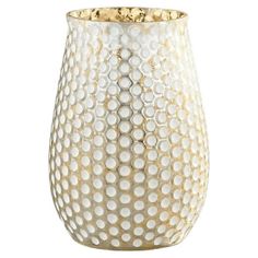 a white vase with gold dots on the outside and inside, sitting on a white surface