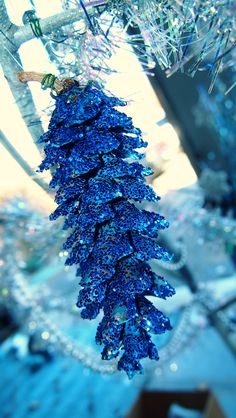 a blue christmas tree ornament hanging from a branch