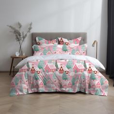 a bed covered in pink and green christmas themed sheets