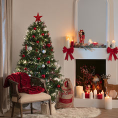 a decorated christmas tree in front of a fireplace with lit candles and presents on the mantle