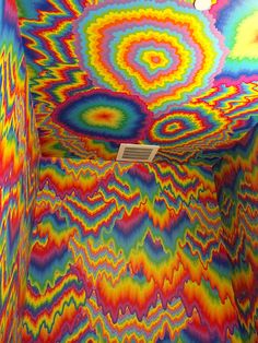 an artistic room with multicolored paint on the walls and ceiling, as well as a light fixture