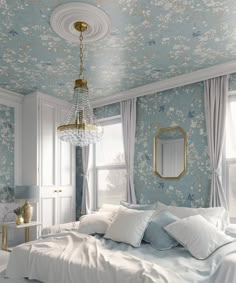 a bedroom with blue and white floral wallpaper, gold chandelier and bed