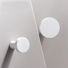 two round knobs on the side of a white cabinet