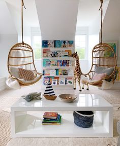 a living room with two hanging chairs and a coffee table