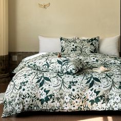 a bed with green and white comforter on top of it