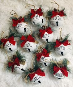 christmas ornaments are arranged in the shape of bells with words on them and pine cones