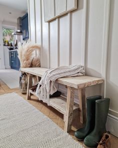 a wooden bench sitting next to a white rug on top of a hard wood floor