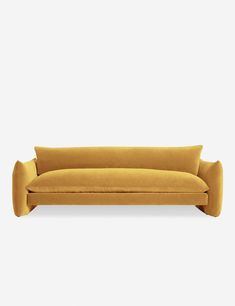 a yellow couch with two pillows on it's back and one arm extended to the side