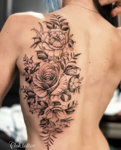 a woman's back with flowers and leaves on it