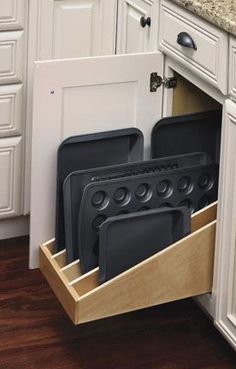 the kitchen drawer is open and has black dishes in it