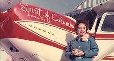 a woman standing in front of an airplane