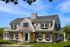 a large house with green shutters on the front and side windows is shown in this image