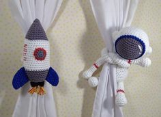 two crocheted stuffed animals hanging from curtains