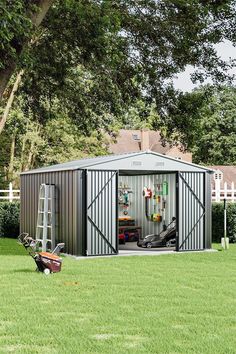 a metal shed sitting on top of a lush green field