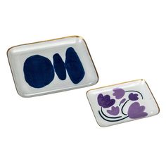 two small plates with designs on them sitting next to each other in front of a white background