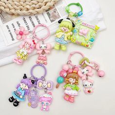 four keychains with cartoon characters on them sitting next to a basket and magazine